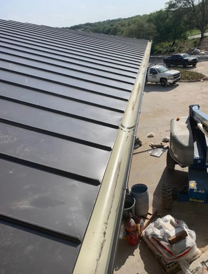 Standing seam panel and gutter detail on a metal roofing jobsite in Highland Park